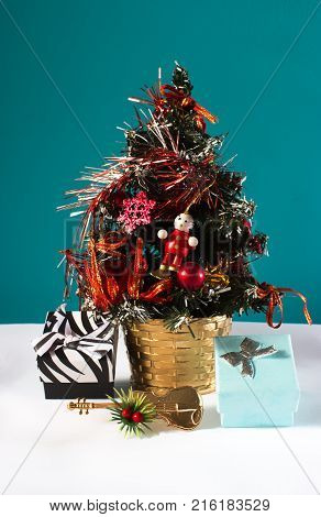 Christmas tree with decoration and two presents and a violin on blue background.