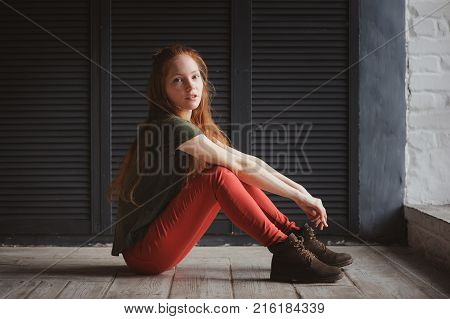 young hipster student woman or creative freelance designer working on project. Holding coursework or business plan.