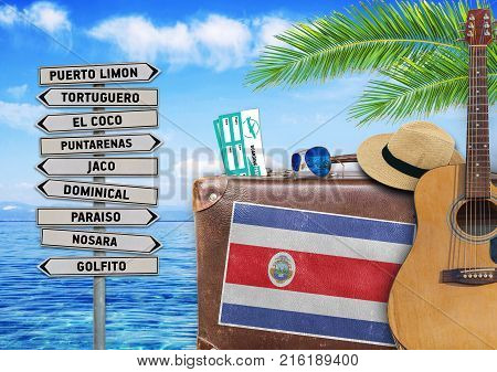 Concept of summer traveling with old suitcase and Costa Rica town sign