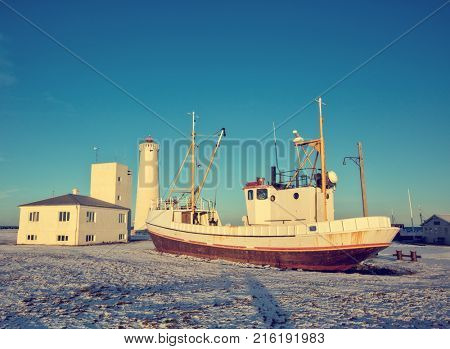 Old fisherman iron boat in Gardur lighthouse area, Iceland. Grunge colored design