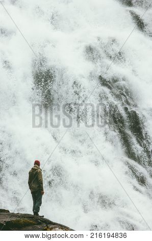 Travel Man standing on cliff at big waterfall outdoor wanderlust Lifestyle concept adventure extreme vacations