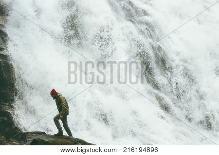 Man walking at big waterfall outdoor Travel Lifestyle survival concept adventure scandinavian vacations in Norway wild nature