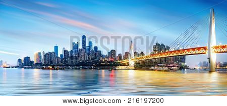 cityscape and skyline of downtown near water of chongqing at night