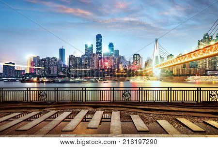 cityscape and skyline of downtown near water of chongqing at night