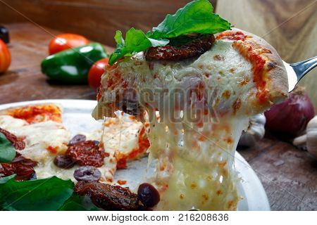 Pizza with mozzarella, rucula and dried tomato