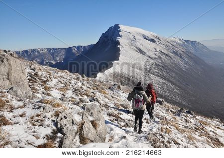 Couple of mountaineers hiking on snowy mountain into the sun. Climbers high in snowy mountains