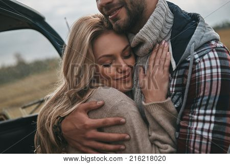 Loving couple. Beautiful young couple embracing and smiling while standing outdoors