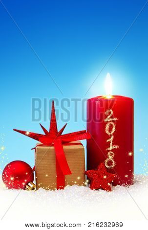 Avent candle and christmas decoration isolated on blue background. Christmas background with snow, candle and gift box .