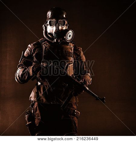 Futuristic nazi soldier gas mask and steel helmet with schmeisser handgun black background studio shot