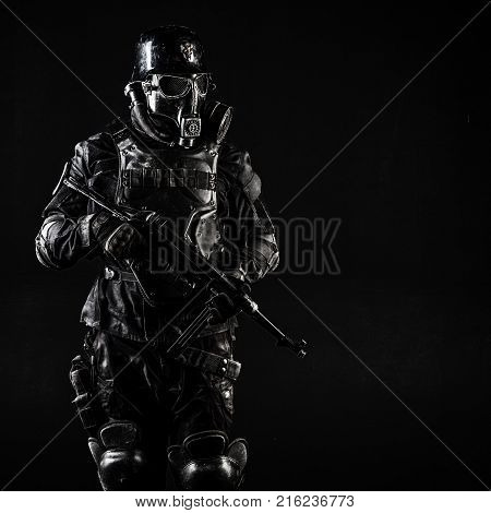 Futuristic nazi soldier gas mask and steel helmet with schmeisser handgun black background studio shot