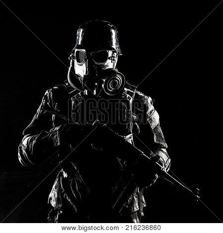 Futuristic nazi soldier gas mask and steel helmet with schmeisser handgun black background studio shot