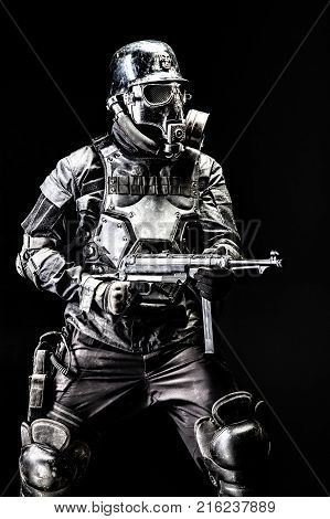 Futuristic nazi soldier gas mask and steel helmet with schmeisser handgun black background studio shot