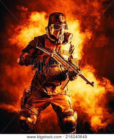 Futuristic nazi soldier in fire and smoke gas mask and steel helmet with schmeisser handgun