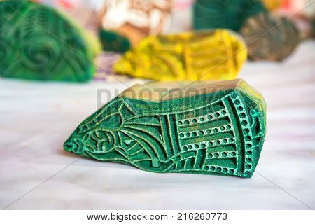 Closeup image of Indian wooden stamp with green dye for cloth
