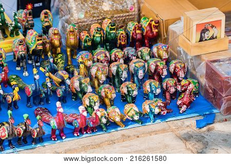 Closeup image of different colorful souvenirs in Indian market with metal figures of Indian goddess