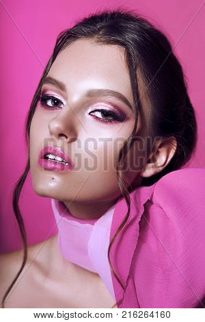 Beautiful Fashionable Girl Haired With Long Curly Hair Posing With A Pink Bow. The Girl In The Studi