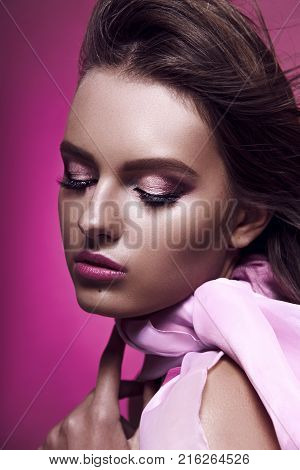 Beautiful Fashionable Girl Haired With Long Curly Hair Posing With A Pink Bow. The Girl In The Studi