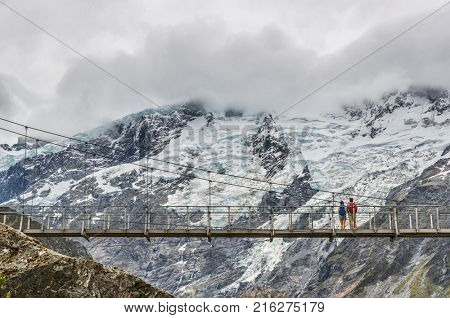 Hooker Valley Track hiking trail, New Zealand. Second swing bridge crossing the river on the Hooker Valley track, Aoraki, Mt Cook National Park with snow capped mountains landscape.