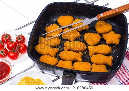 Fried fish sticks in frying pan. Studio Photo
