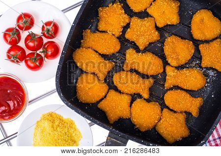 Fried fish sticks in frying pan. Studio Photo