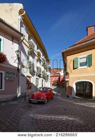 MURAU/ AUSTRIA - OCTOBER 7, 2017. Volkswagen beetle car on the beautiful one-way street in the historical town center of Murau. Styria, Austria.