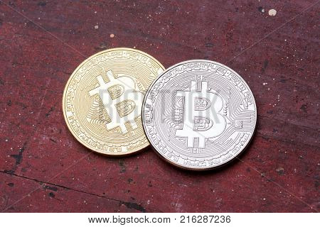 Silver and golden bitcoins on red background. High resolution photo.