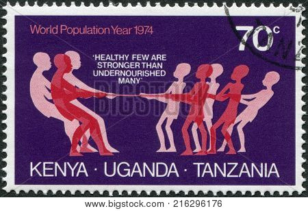 EAST AFRICAN COMMUNITY - CIRCA 1974: A stamp printed in East African Community, is dedicated to World Population Year, shows a tug of war with the malnourished, circa 1974