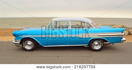 FELIXSTOWE, SUFFOLK, ENGLAND - AUGUST 27, 2016: Classic Blue Pontiac Star Chief Motor Car  parked on seafront promenade.