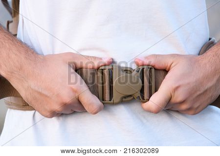 The Young Man Fastens Itself To The Fastex Buckle On The Chest From The Backpack