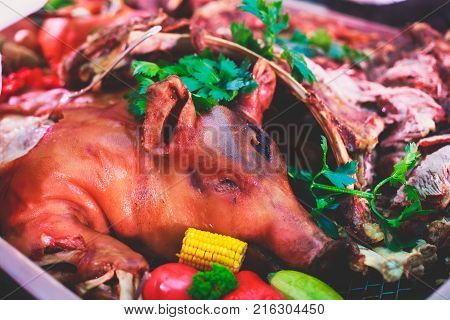 Big Giant Dish Plate With Roasted Full Pig Pork Head, Served In Restaurant With Variety Of Vegetable