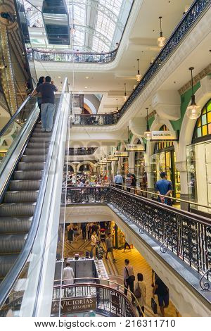 SYDNEY AUSTRALIA - NOVEMBER 24 2017; Inside destination retail center trendy and classy Queen Victoria Building retail arcade with peoplein cafe on different levels and riding escalator up.