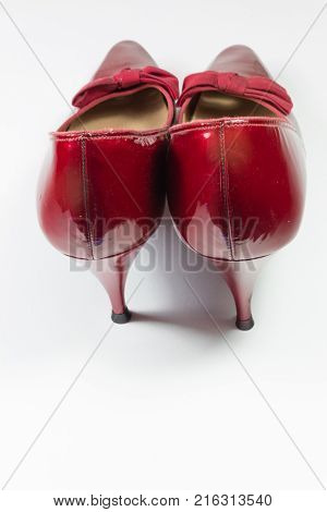Pair of vintage women's ruby red shoes viewed from the rear isolated on white vertical aspect