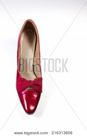 Top view of a vintage woman's shoe in ruby red pleather isolated on white vertical aspect
