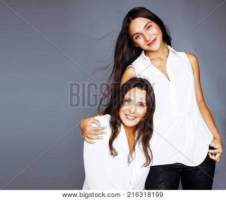 cute pretty teen daughter with mature mothr hugging, fashion style brunette