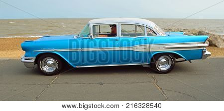 FELIXSTOWE, SUFFOLK, ENGLAND - AUGUST 27, 2016: Classic Blue Pontiac Star Chief Motor Car  parked on seafront promenade.