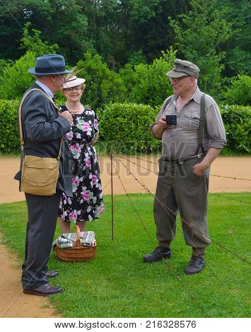 SILSOE, BEDFORDSHIRE, ENGLAND - MAY 28, 2017:  Two Men and a Woman Dressed in  in Second World War Clothes and Uniform.