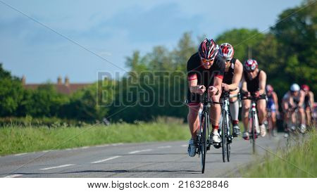 GRAFHAM, CAMBRIDGESHIRE, ENGLAND - MAY 22, 2016:  Triathletes on road cycling stage of triathlon.
