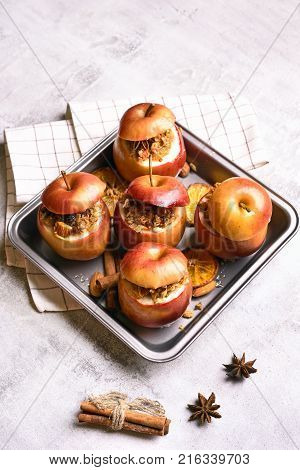 Baked apples with granola cinnamon nuts and honey on stone background. Healthy ftuit dessert.