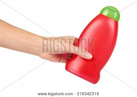 Red plastic bottle for shampoo in hand isolated on white background. Hydiene and cleaning idea.