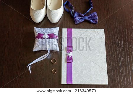 wedding accessories. bridal shoes and rings on wooden background