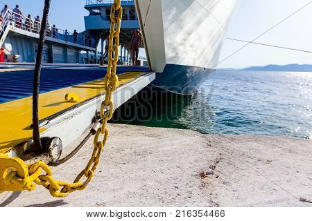 Anchored large ferryboat has open front entrance at the local port.