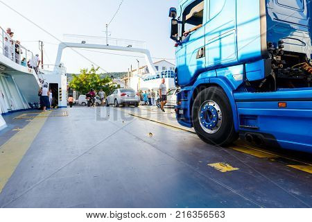 Pefki Island Evia Greece - 11 July 2017: Anchored large ferryboat has opened his front entrance for unloading people tourists and vehicles at the local harbor