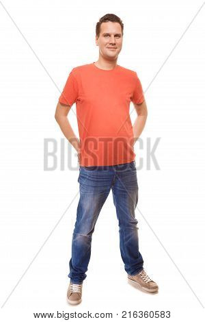 Full length young man wearing red t-shirt jeans casual fashion style with hands in pockets isolated on white background