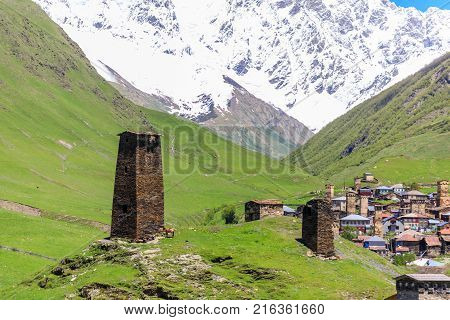 View of the Ushguli village at the foot of Mt. Shkhara. Picturesque and gorgeous scene. Rock tower in Ushguli - the highest inhabited village in Europe