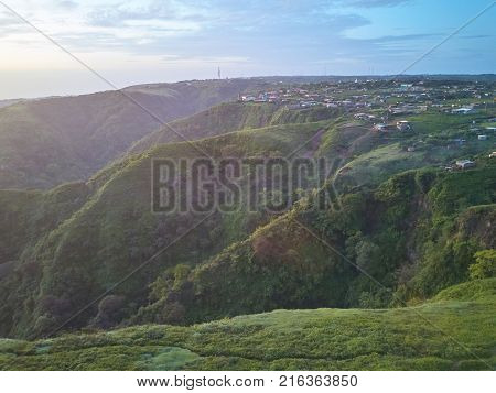 Panorama of houses on green hills in dusk time. Poor people homes in third country