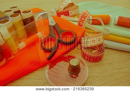 Sewing tools and sewing kit on wooden textured background. Sewing kit. Thread needles and cloth. tailor workspace with sewing and handmade tools