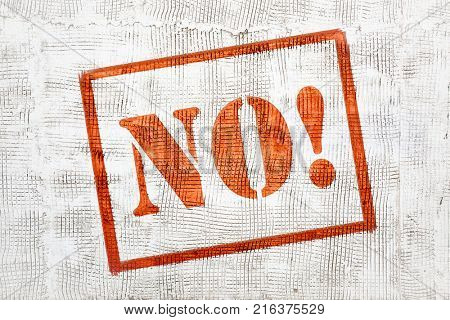 NO! - red graffiti sign on white stucco wall