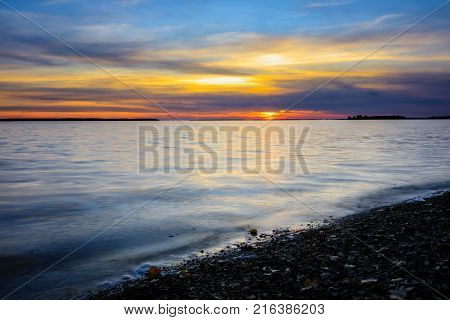 Nightfall overlooking Lac St Louis Lachine Quebec from the walking path with the sun behind the horizon.
