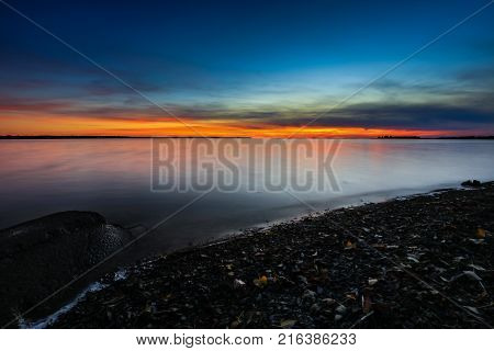 Nightfall overlooking Lac St Louis Lachine Quebec from the walking path with the sun behind the horizon.