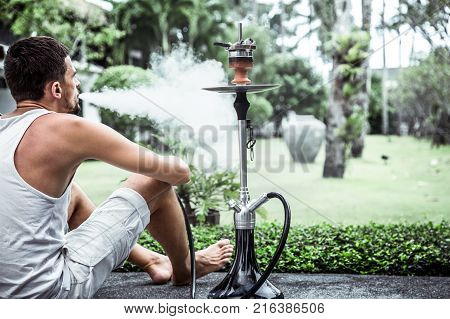 man smoking a hookah on vacation background lifestyle concept